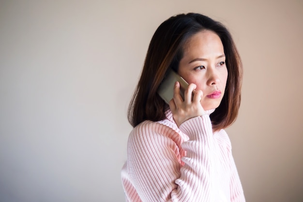 Mittlere erwachsene asiatische Frau, die Handy verwendet