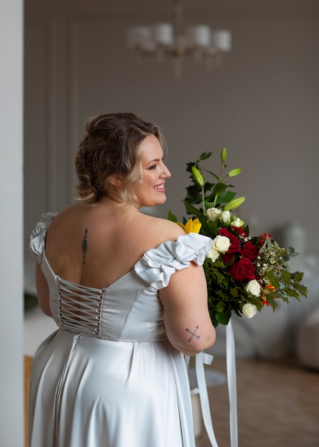 Foto mittlere schussbraut, die mit blumen aufwirft