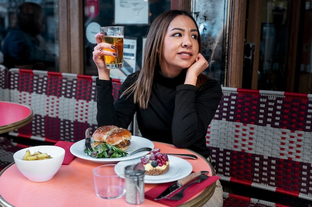 Mittlere Schussfrau am Bistro mit Getränk