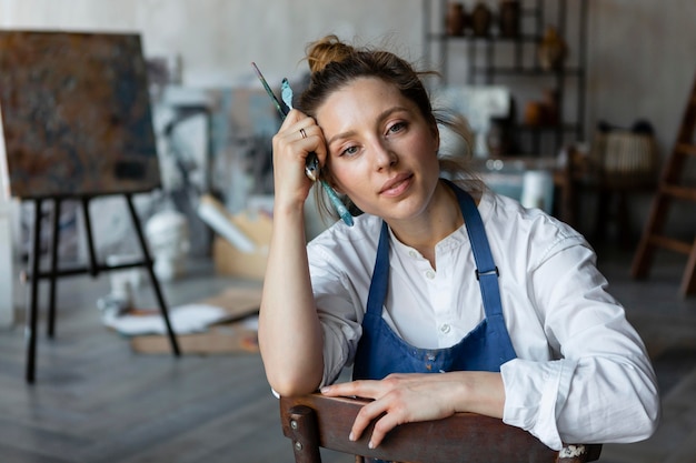 Foto mittlere schussfrau, die auf stuhl sitzt