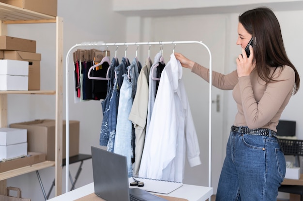 Foto mittlere schussfrau, die kleidung prüft