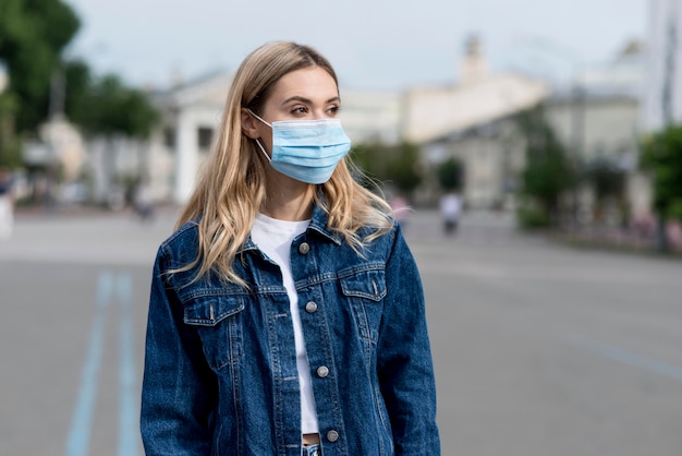 Mittlere Schussfrau, die medizinische Maske trägt