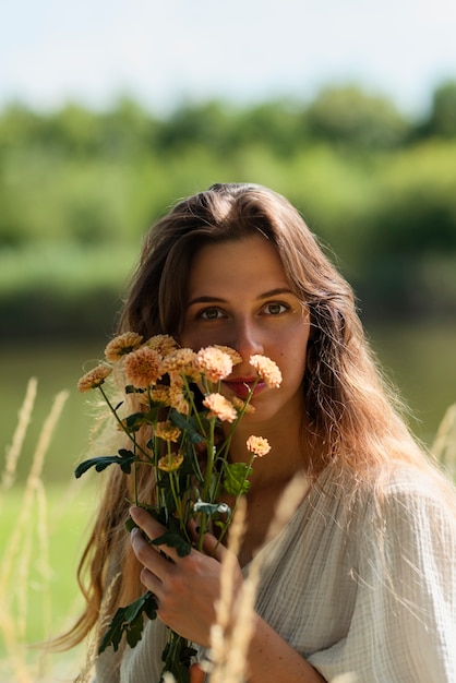 Foto mittlere schussfrau, die mit blumen aufwirft