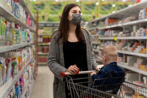 Foto mittlere schussfrau, die mit kind einkauft