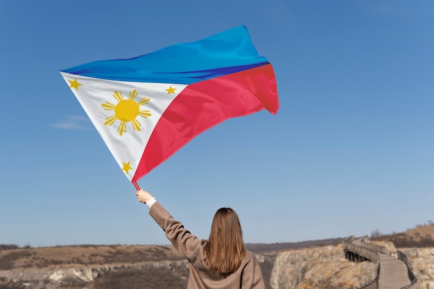 Foto mittlere schussfrau, die philippinische flagge hält