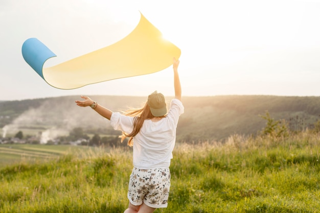 Mittlere Schussfrau, die Yogamatte hält