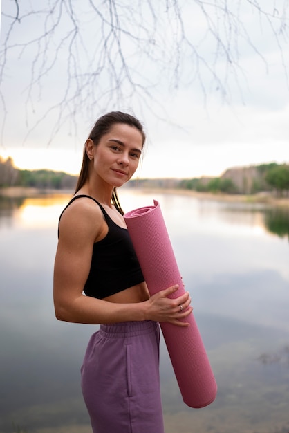 Foto mittlere schussfrau mit yogamatte