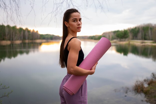 Foto mittlere schussfrau mit yogamatte