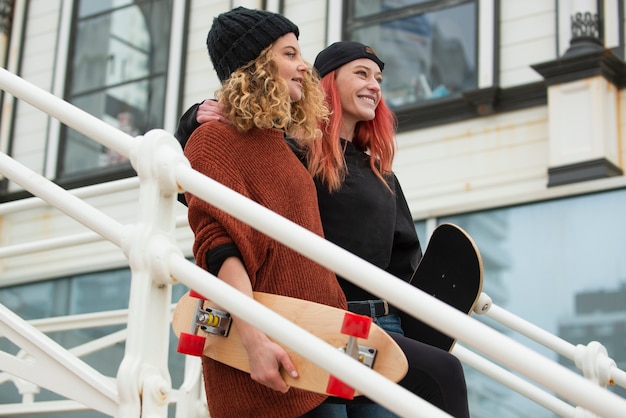 Foto mittlere schussfrauen, die mit skateboards gehen