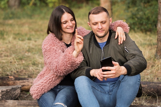 Mittlere Schusspartner, die Telefon betrachten