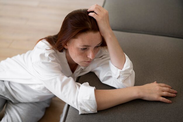 Mittlere traurige Frau mit Couch