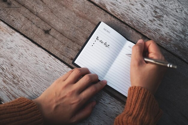 Mittlerer Abschnitt einer Person, die ein Buch auf dem Tisch liest