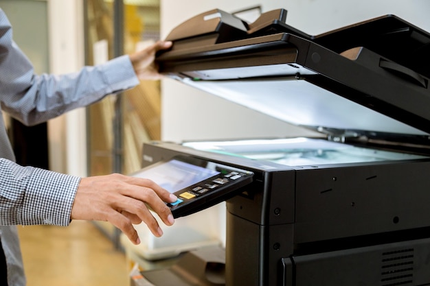 Foto mittlerer abschnitt eines mannes, der im büro ein papierfotokopiergerät druckt