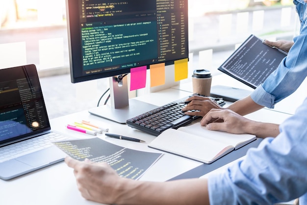 Mittlerer Abschnitt von Programmierern, die an einem Tisch arbeiten