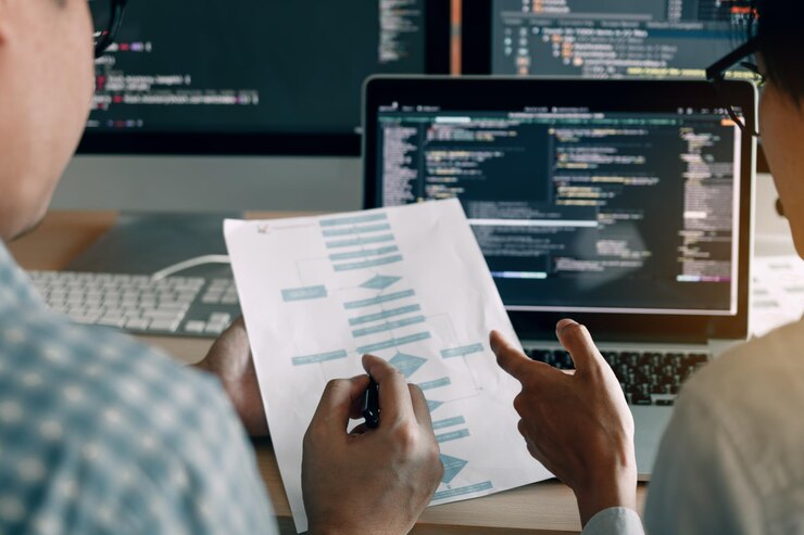 Foto mittlerer abschnitt von programmierern, die im büro an diagrammen arbeiten