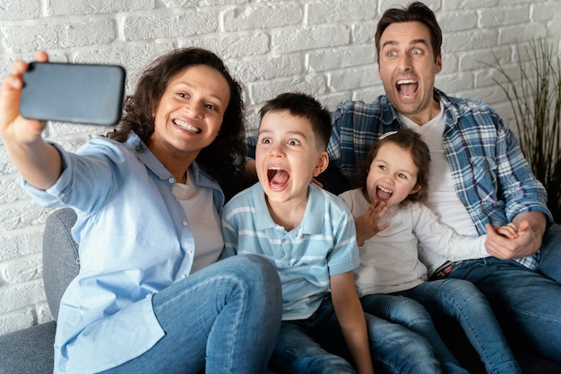 Mittlerer Schuss glückliche Familie, die Selfies nimmt