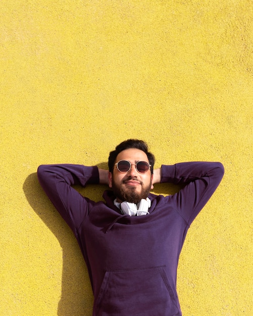 Foto mittlerer schuss junge, der mit sonnenbrille liegt