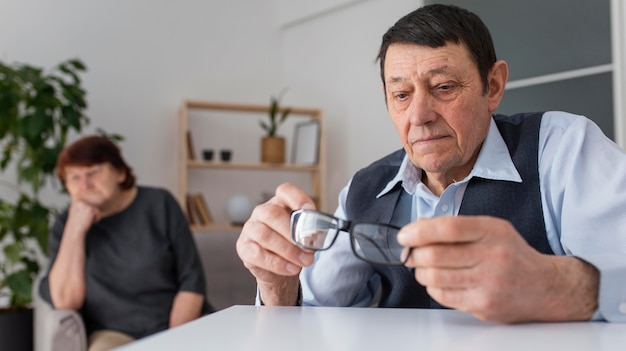 Foto mittlerer schuss mann, der brille hält