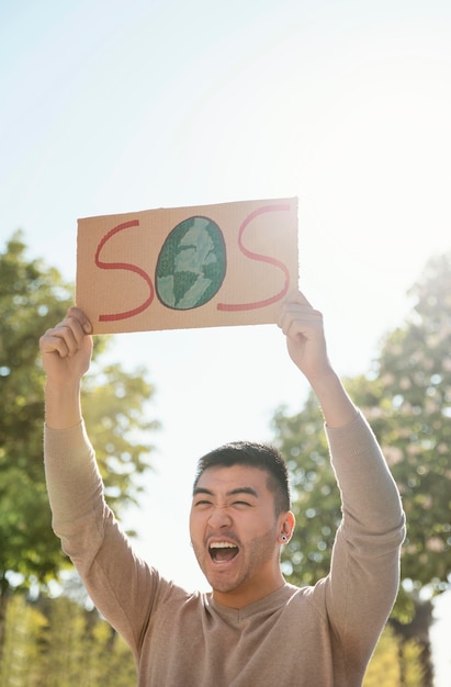 Mittlerer Schuss Mann, der mit Plakat schreit