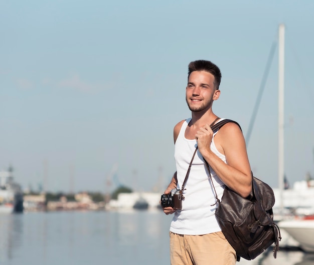 Foto mittlerer schuss smiley-mann, der kamera hält