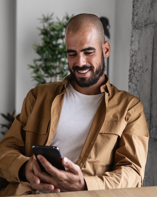 Foto mittlerer schuss smiley-mann mit smartphone