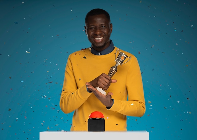 Foto mittlerer schuss smiley-mann mit trophäe