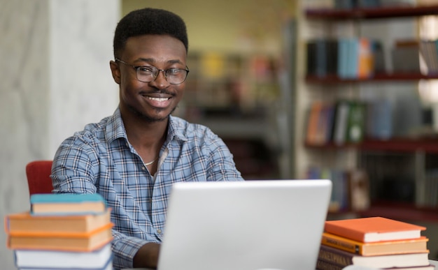 Foto mittlerer schuss smiley-student mit laptop