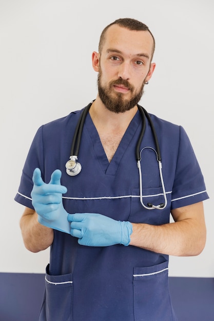 Foto mittlerer schussdoktor mit stethoskop und handschuhen