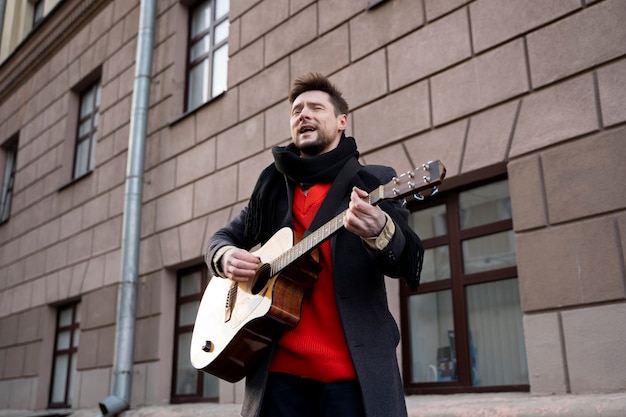 Foto mittlerer schussmann, der die gitarre spielt