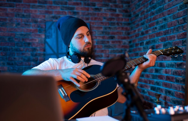 Foto mittlerer schussmann, der gitarre spielt