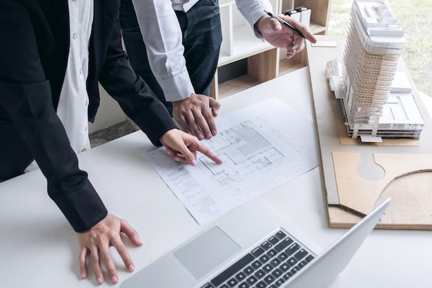 Mittlerer Teil der Ingenieure diskutiert über die Blaupause im Büro
