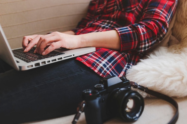 Mittlerer Teil einer Frau, die zu Hause sitzend einen Laptop benutzt