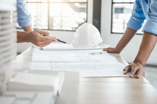 Mittlerer Teil von Architekten, die im Büro an einem Bauplan arbeiten