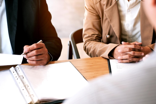 Mittlerer Teil von Geschäftsleuten sitzt neben einem Kollegen im Büro