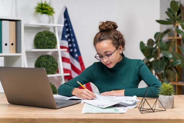 Foto mittleres schussmädchen mit laptopschreiben am schreibtisch