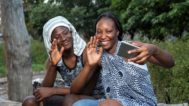 Foto mittleres schusspaar, das am telefon winkt