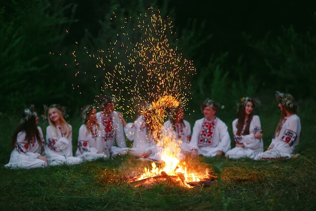 Mittsommernacht, junge Leute in slawischer Kleidung sitzen am Lagerfeuer.