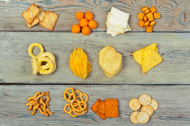 Mix von Snacks: Brezeln, Cracker, Pommes und Nachos auf dem Tisch