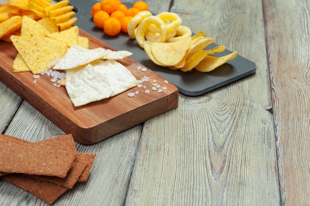 Mix von Snacks: Brezeln, Cracker, Pommes und Nachos auf dem Tisch