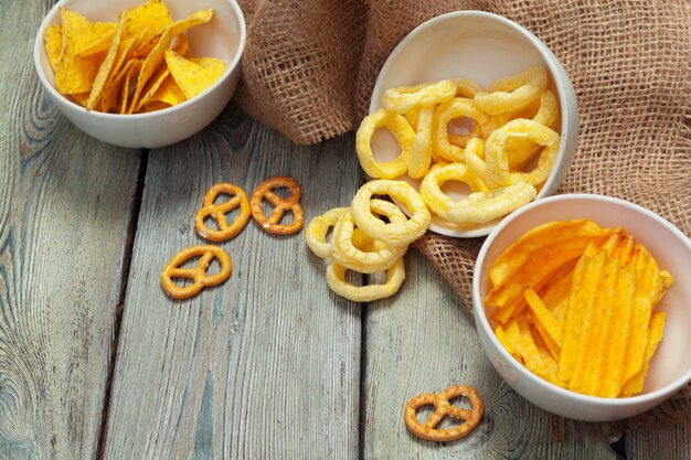 Mix von Snacks: Brezeln, Cracker, Pommes und Nachos auf dem Tisch