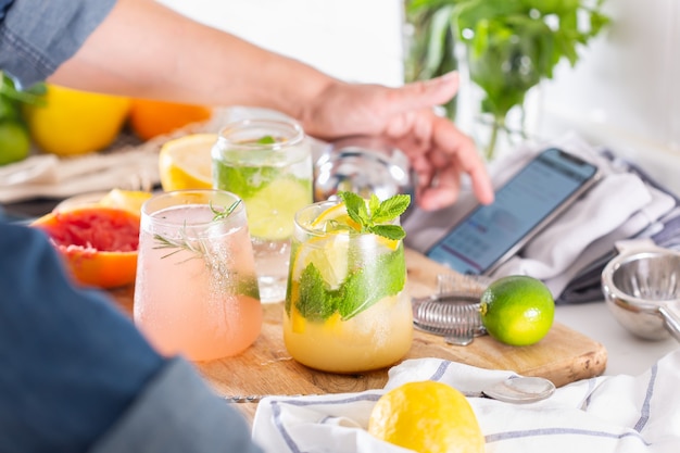 Mixólogo haciendo refrescantes cócteles con agua mineral en casa