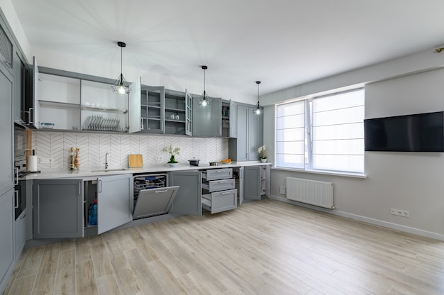 Mobiliario de cocina moderno gris y blanco de moda con puertas abiertas