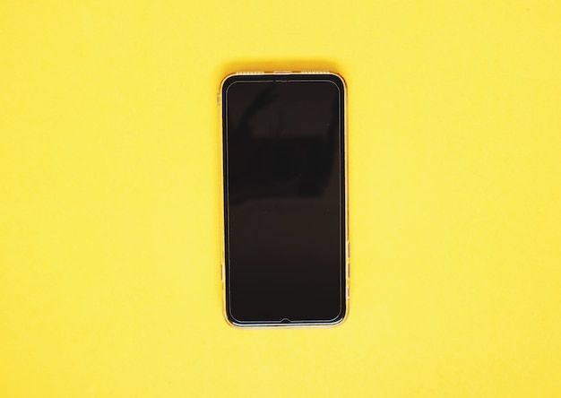 Mobiltelefon des leeren bildschirms auf gelbem hintergrund.