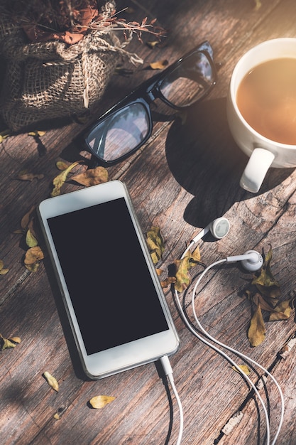 Foto mobiltelefon mit tasse kaffee auf holztisch