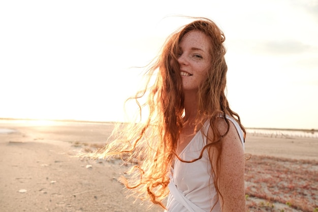 Foto moça bonita com cabelo vermelho longo e saudável e vestido bonito