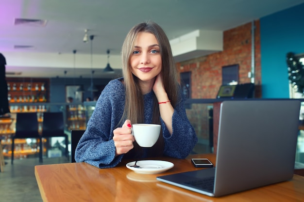 Moça bonita que descansa em um café