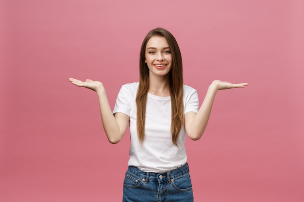 Moça com a camisa branca que aponta a mão no lado para apresentar um produto