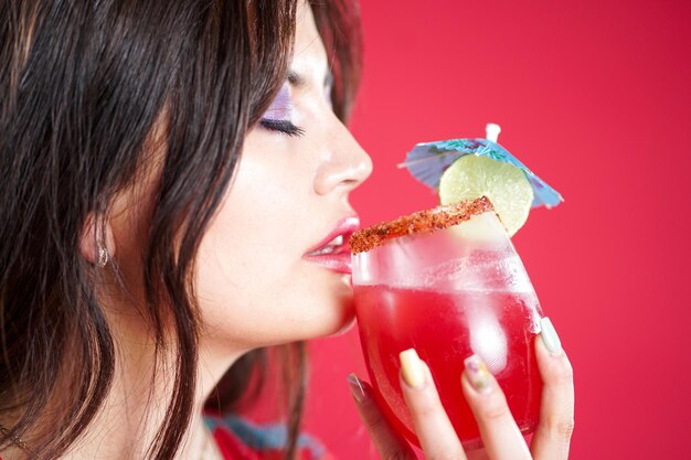 Foto moça com bebida refrescante à disposição no estúdio vermelho