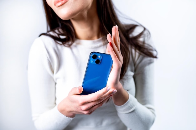 Moça com celular nas mãos Novo smartphone apresentado nas mãos da mulher