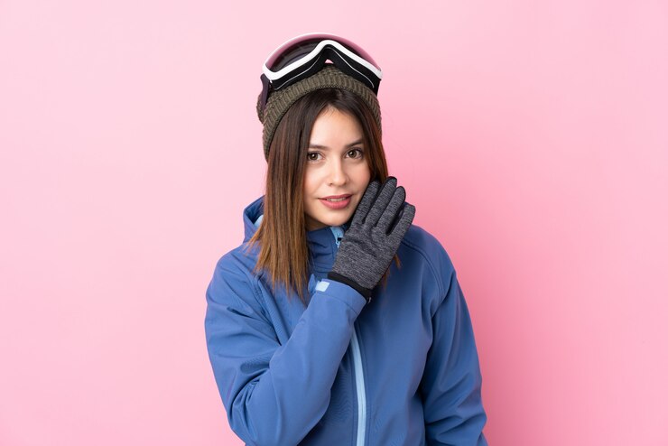 Foto moça com chapéu do inverno sobre a parede cor-de-rosa